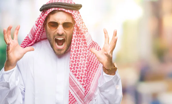 Yakışıklı delikanlı deli ve silah ile başarı için deli kutluyor izole arka plan üzerinde keffiyeh giyen kaldırdı ve heyecanlı çığlık gözler kapalı. Kazanan kavramı