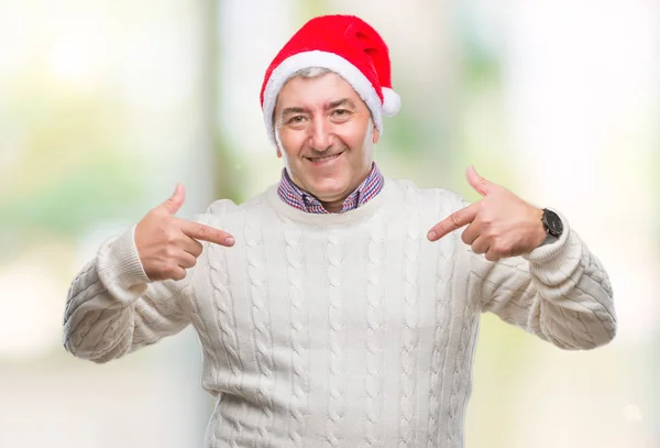 ハンサムな年配の男性の顔に笑顔と自信を持って 誇りと幸せな指で自分を指している孤立した背景にクリスマスの帽子をかぶって — ストック写真