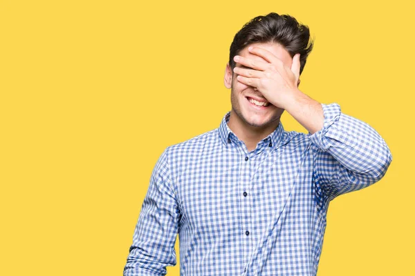 Genç yakışıklı iş adamı gülümsüyor ve gözleri için sürpriz kapsayan yüz el ile gülüyor izole arka plan üzerinde. Kör kavramı.