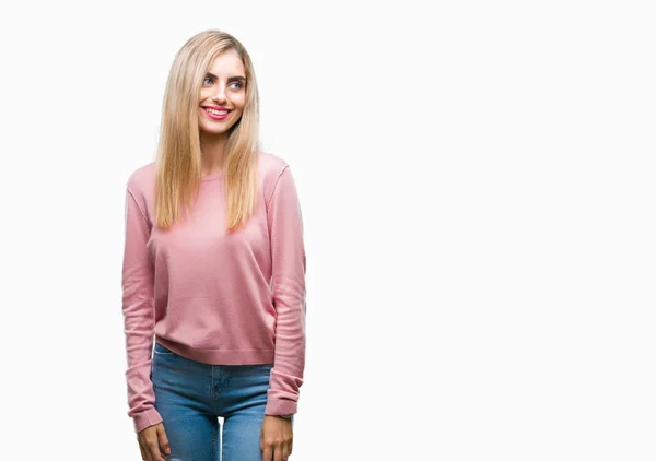 若い美しい金髪女性の孤立した背景が笑顔で側に自然な表現の顔に離れて見るピンク冬セーターを着ています 自信を持って笑ってください — ストック写真