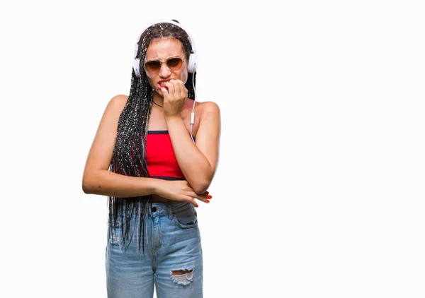 年轻的编织头发非洲裔美国人与出生标志戴耳机在孤立的背景看起来紧张和紧张的手在嘴咬指甲 焦虑问题 — 图库照片