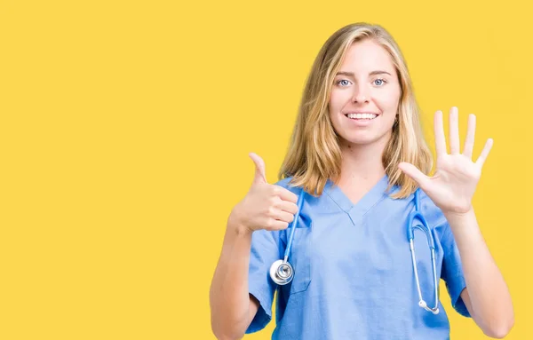 美丽的年轻医生妇女穿着医疗制服在孤立的背景显示和手指第六 同时微笑着自信和快乐 — 图库照片