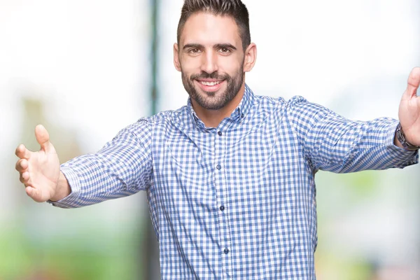 Yakışıklı delikanlı sarılmak için kollarını açarak gülümseyerek kameraya bakarak izole arka plan üzerinde. Neşeli ifade kucaklayan mutluluk.