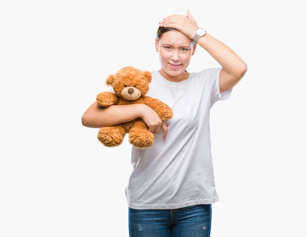 Mujer Caucásica Joven Sosteniendo Osito Peluche Sobre Fondo Aislado Estresado —  Fotos de Stock