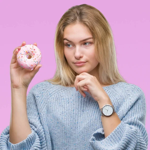 Jovem Caucasiana Comendo Donut Doce Sobre Fundo Isolado Rosto Sério — Fotografia de Stock