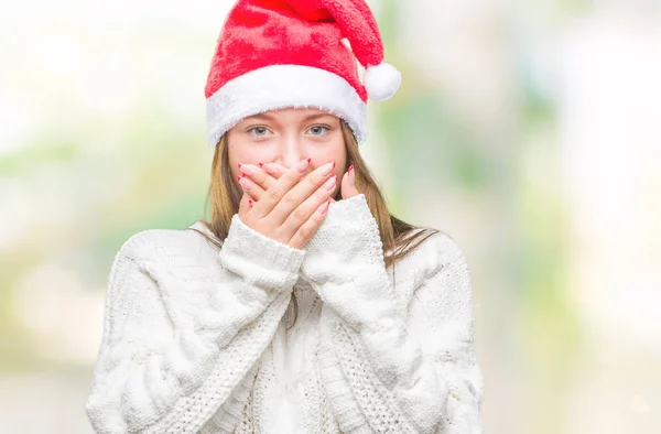 年轻美丽的高加索妇女戴着圣诞帽在孤立的背景震惊覆盖嘴与手的错误 秘密概念 — 图库照片