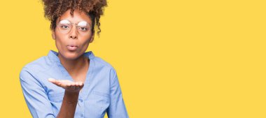 Güzel genç Afro-Amerikan iş kadını bir öpücük el ile güzel ve seksi olmak hava üfleme kamera bakarak izole arka plan üzerinde. Aşk ifade.