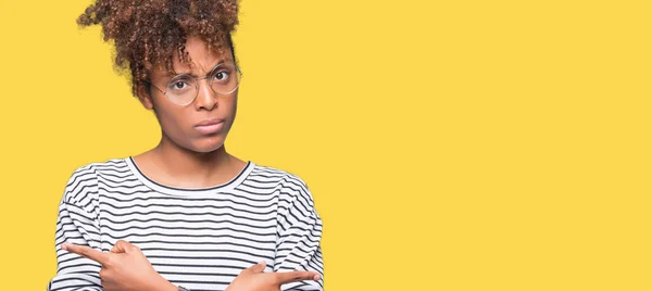 美しい若いアフリカ系アメリカ人女性分離で眼鏡をかけて背景ポインティング指 別の方向で両側に反対 — ストック写真
