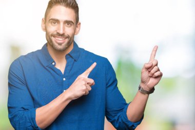 Yakışıklı delikanlı gülümseyen ve iki elleri ve parmakları ile tarafına işaret kamera bakarak izole arka plan üzerinde.