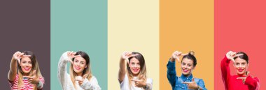 Kolaj elle yapma çerçeve ve parmakları ile mutlu yüz gülümseyen renkli vintage izole arka plan üzerinde genç güzel kadın. Yaratıcılık ve Fotoğrafçılık kavramı.