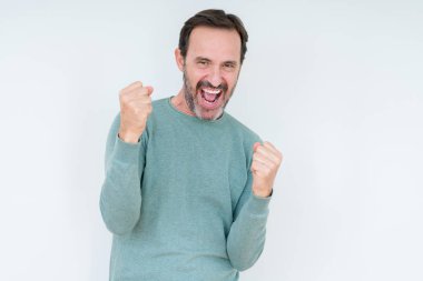 Gülümseyen ve başarı için çığlık üst düzey adam izole arka plan çok mutlu ve heyecanlı kaldırdı, silah ile kazanan jest yapıyor. Kutlama kavramı.