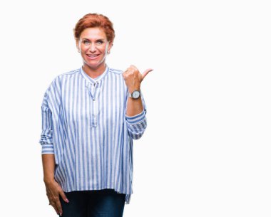 Atrractive üst düzey beyaz Kızıl saçlı kadın arıyorum ve başparmak yanında yukarıyı mutlu yüz ile gülümseyen izole arka plan.