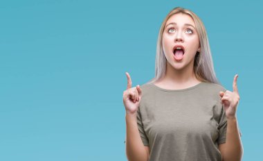 Sarışın genç kadın izole arka plan üzerinden hayran ve yukarıya bakıp parmakları ile işaret şaşırttı ve silah kaldırdı.