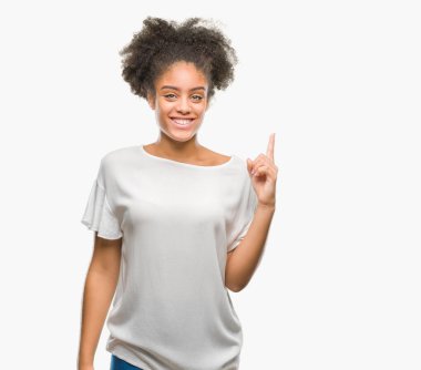 Genç afro Amerikalı kadın ve kendinden emin ve mutlu gülümseyerek süre parmak numaralı yukarıyı gösteren izole arka plan üzerinde.