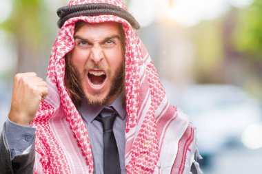 Uzun saçlı keffiyeh üzerinde giyen genç yakışıklı Arap adam arka plan kızgın izole ve kızgın yetiştirme hayal kırıklığı ve öfke ile bağırarak süre öfkeli yumruk. Öfke ve agresif kavramı.