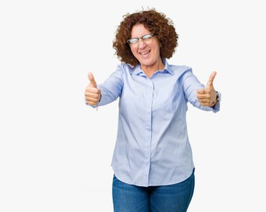 El ile pozitif jest yapıyor onaylama izole arka plan üzerinde gözlük güzel orta ager üst düzey businees kadın başparmak gülümseyen ve başarı için mutlu. Kamera, kazanan jest arıyorsunuz.