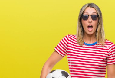 Futbol futbol topu izole arka plan üzerinde bir sürpriz yüz, korkuyor ve heyecanlı korku ifadesi ile şok korkmuş tutan genç güzel kadın
