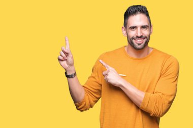 Yakışıklı delikanlı gülümseyen ve iki elleri ve parmakları ile tarafına işaret kamera bakarak izole arka plan üzerinde.