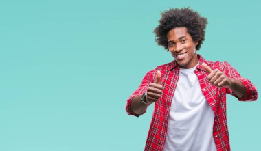 El ile pozitif jest yapıyor onaylama izole arka plan üzerinde Afro Amerikalı adam başparmak gülümseyen ve başarı için mutlu. Kamera, kazanan jest arıyorsunuz.