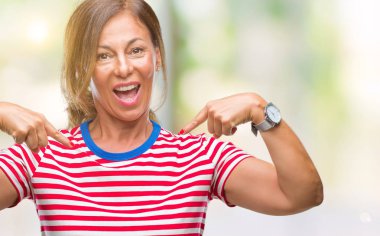 Orta yaş yüzünde gülümseme ile kendinden emin görünüyorsun, kendini gururlu ve mutlu parmakları ile işaret izole arka plan üzerine İspanyol kadın kıdemli.