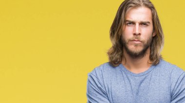 Yakışıklı delikanlı izole arka plan şüpheci ve sinir, onaylamayan ifade yüz çapraz kolları olan uzun saçlı. Negatif kişi.