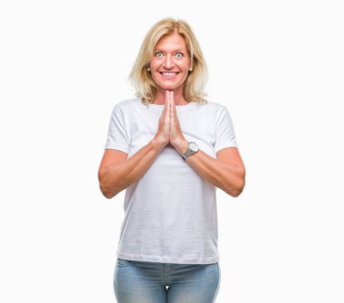 Orta yaş sarışın kadın ellerle birlikte AF emin gülümseyen için soran dua izole arka plan üzerinde.