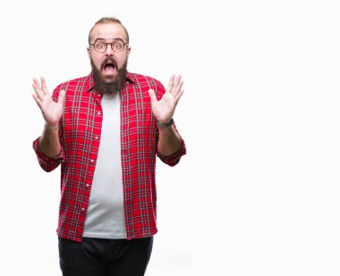 Üzerinde gözlük takan Genç beyaz hipster adam deli kutluyor arka plan izole ve çığlık kaldırdı ve açık gözleri heyecanlı silah ile başarı için hayrete düşürdü. Kazanan kavramı