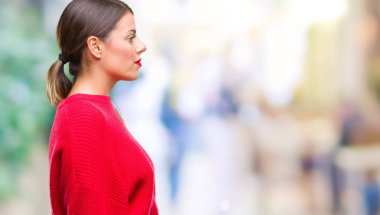 Genç güzel iş kadın giyiyor kış kazak izole arka tarafına, seyir üzerinde dinlenmek doğal yüz emin gülümseme ile pozuyla profili.