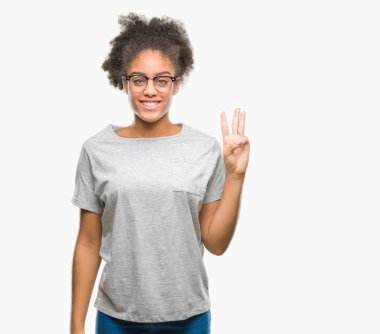 Genç afro Amerikalı kadın gözlük gösterilen ve parmakları ile işaret izole arka plan üzerinde ise kendinden emin ve mutlu gülümseyerek üçüncüsü.