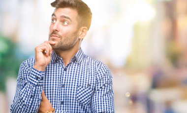 Yakışıklı delikanlı çene düşünme hakkında soru, dalgın ifade üzerine el ile izole arka plan üzerinde. Düşünceli yüzüyle gülümsüyor. Şüphe kavramı.