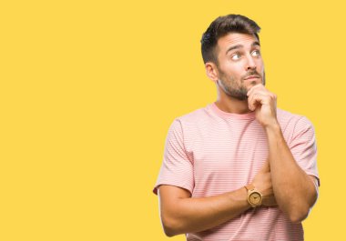 Yakışıklı delikanlı çene düşünme hakkında soru, dalgın ifade üzerine el ile izole arka plan üzerinde. Düşünceli yüzüyle gülümsüyor. Şüphe kavramı.