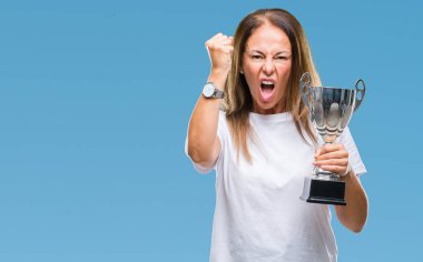 Orta yaş İspanyol kazanan kadın Ödülü holding Trophy üzerinde izole arka rahatsız ve öfke, çılgın ve yükseltilmiş el, öfke kavramı ile diye bağıran ile sinirli bağırarak kutluyor