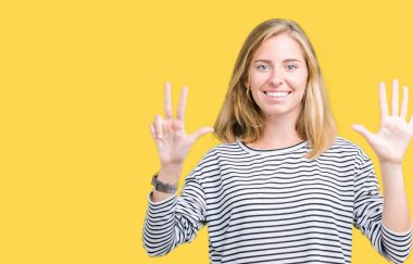 Güzel genç kadın giyiyor çizgili süveter gösterilen ve parmakları ile işaret izole arka plan üzerinde kendinden emin ve mutlu gülümseyerek süre sekiz numara.