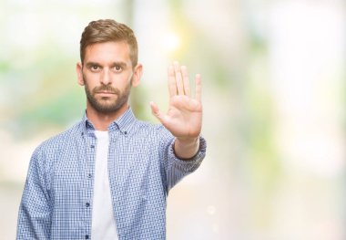 Yakışıklı delikanlı dur yapıyor izole arka plan üzerinde beyaz t-shirt giyen elin avuç ile şarkı. Negatif ve ciddi bir jest yüz ifadesiyle uyarı.