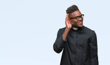 Bir işitme söylenti ya da dedikodu için dinleme kulak üzerinde el ile gülümseyen izole arka plan genç Afro-Amerikan rahip adam. Sağırlık kavramı.