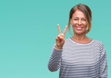 Orta yaş gösterilen ve parmakları ile işaret izole arka plan üzerine İspanyol kadın kıdemli ikincisi ise kendinden emin ve mutlu gülümseyerek.