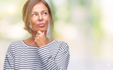 Orta yaş İspanyol kadın kıdemli emin çapraz kollar ve çeneme kaldırdı el ile gülümseme ile kameraya bakarak izole arka plan üzerinde. Pozitif düşünce.