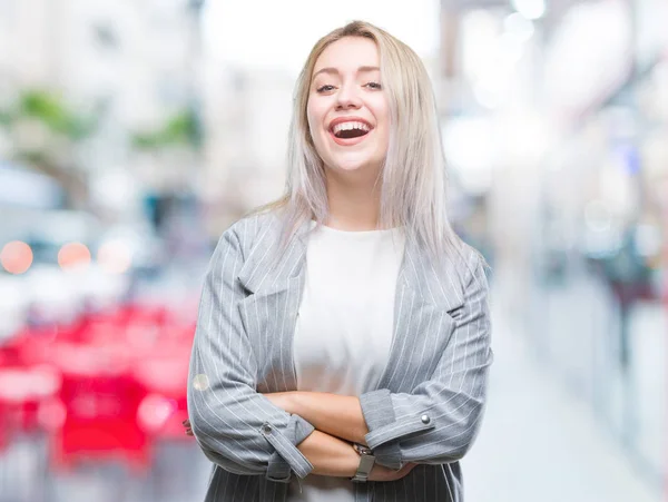 Young blonde business woman wearing jacket over isolated background happy face smiling with crossed arms looking at the camera. Positive person.