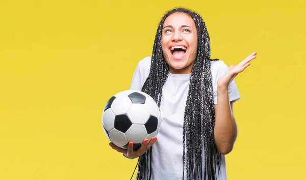 編んだ髪の若いアフリカ系アメリカ人女の子持株サッカー ボール分離背景非常に幸せと興奮 勝者式笑顔で叫んで勝利を祝ってと手を上げたに対する — ストック写真