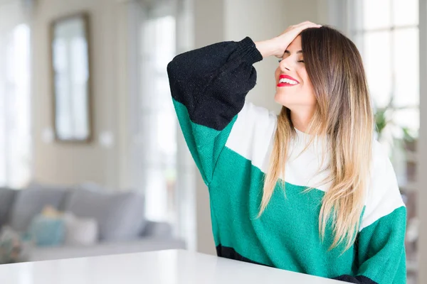 冬のセーターを着て家で若い美しい女性の笑顔手ジェスチャーを自信を持って触れる髪魅力的なポーズ — ストック写真