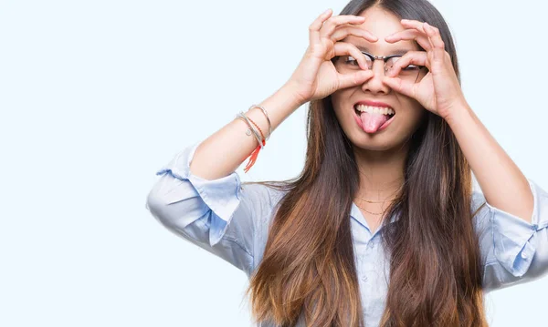 年轻的亚洲女商人戴眼镜在孤立的背景做确定的手势像双筒望远镜伸出舌头 眼睛通过手指看 疯狂的表达 — 图库照片