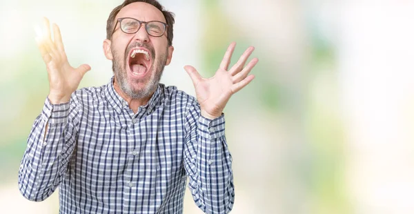 Kızgın ve silah ile başarı için deli kutluyor izole arka plan üzerinde gözlük takan yakışıklı orta yaş zarif komuta sizde kaldırdı ve heyecanlı çığlık gözler kapalı. Kazanan kavramı