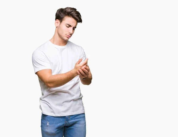 年轻英俊的男人穿着白色 T恤在孤立的背景下遭受疼痛的手和手指 关节炎炎症 — 图库照片