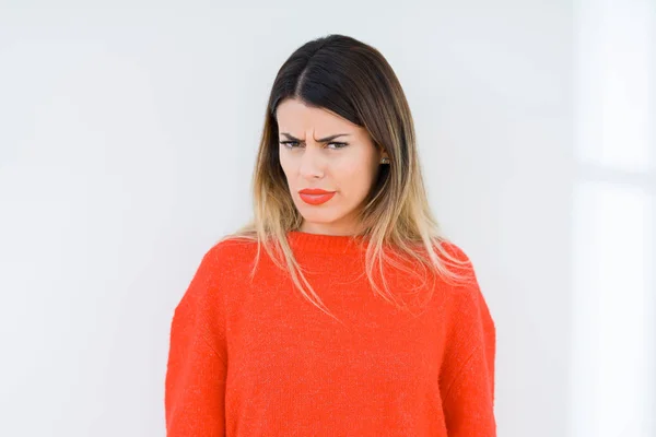 問題のため懐疑的な孤立した背景と神経質 しかめっ面の動揺をカジュアルな赤いセーターを着た若い女性 否定的な人 — ストック写真