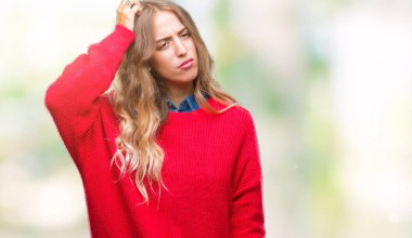 Güzel sarışın genç kadın giyiyor kış kazak izole arka plan üzerinde yanıltır ve soru hakkında merak ediyorum. Şüphe, kafasına el ile düşünme ile belirsiz. Dalgın kavramı.