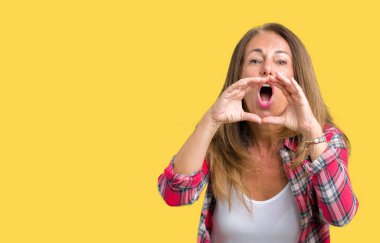 Ağzına sesle elleriyle kızgın bağırarak izole arka plan üzerinde giyen güzel orta yaş kadın
