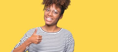 Güzel genç Afro-Amerikan kadın hareketi el ile mutlu yaşasın yapıyor izole arka plan üzerinde gözlük takıyorum. Başarı gösteren kameraya bakarak ifade onaylama.