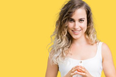 İzole arka plan el ele tutusun güzel genç sarışın kadın ve rahat ve neşeli gülümseyen parmak çarpı işareti. Başarı ve iyimser