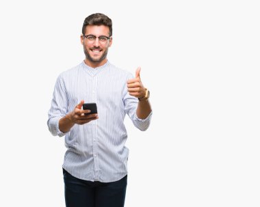 Yakışıklı delikanlı manifatura üzerinden Smartphone kullanarak arka plan mutlu ok işareti, başparmak ile parmak, mükemmel işareti yapıyor kocaman bir gülümseme ile izole
