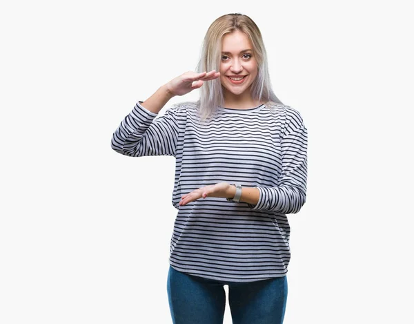 メジャー シンボル兆し大きな 大きなサイズの手で身振りで示す分離の背景の上の若いブロンドの女性 カメラを見て笑っています 測定概念 — ストック写真